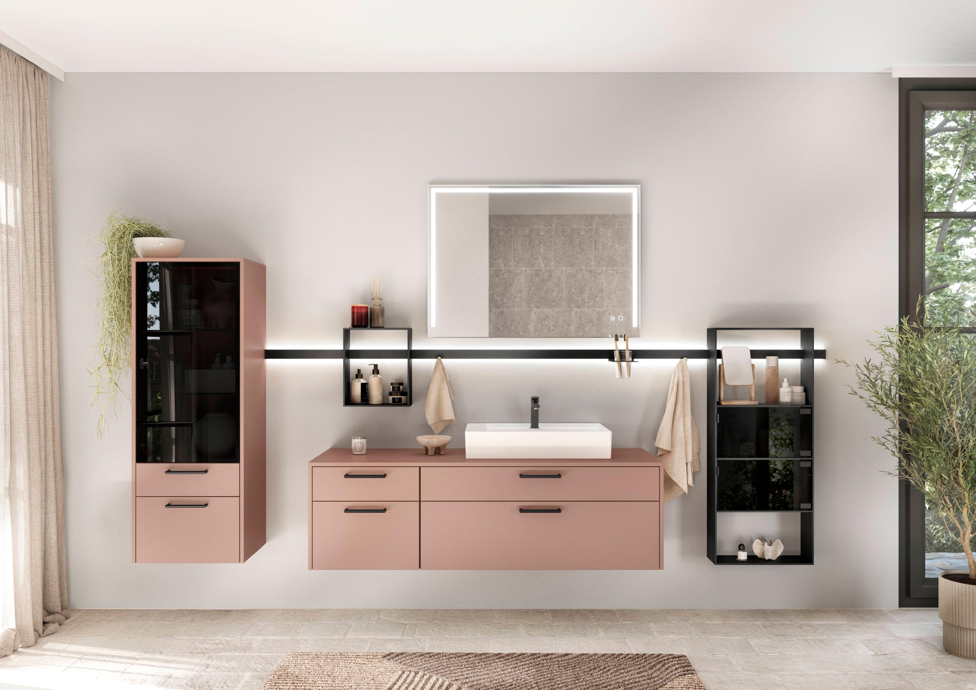 Modernes Badezimmer in Altrosa mit Waschtisch, beleuchtetem Spiegel und schwarzen Regalakzenten.