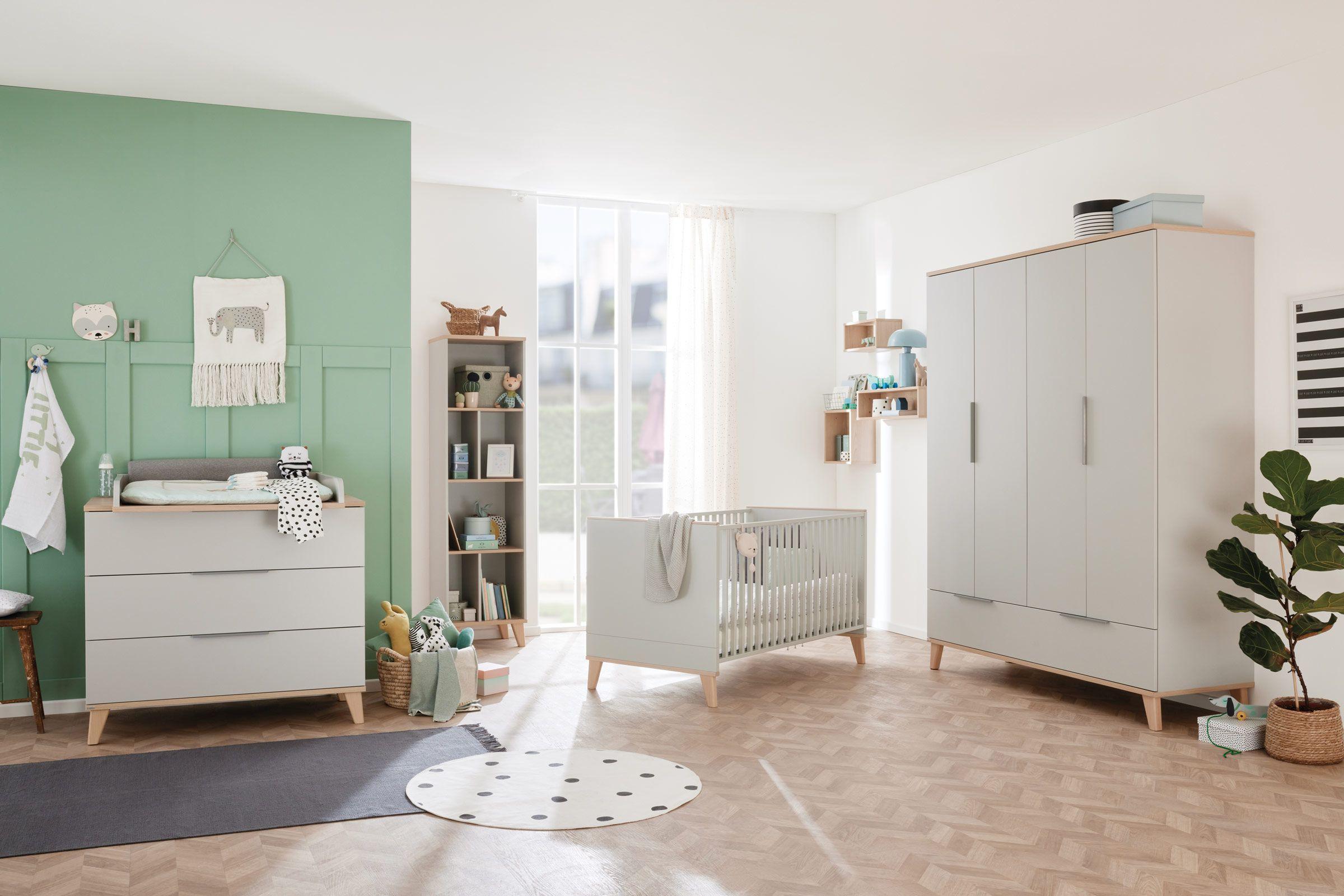 Modernes Babyzimmer in sanften Grün- und Naturtönen mit Wickelkommode, Gitterbett, großem Kleiderschrank und liebevoller Dekoration.
