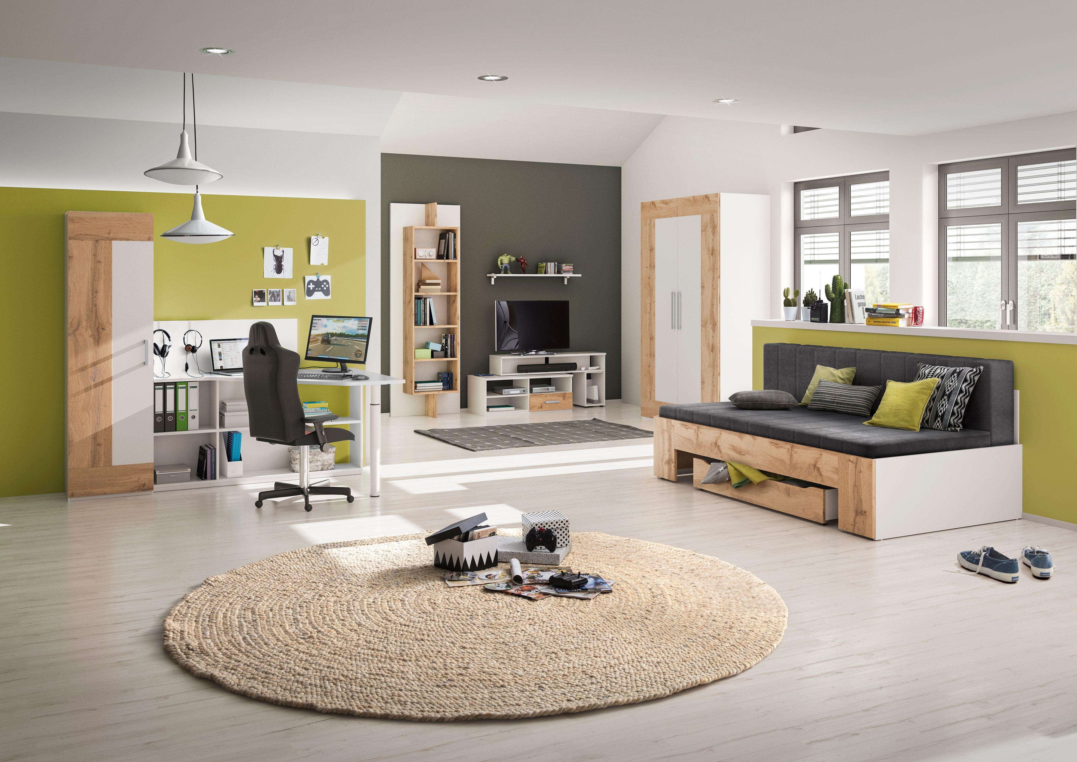 Modern eingerichtetes Jugendzimmer mit Gaming-Schreibtisch, gemütlichem Sofa mit Bettfunktion, Kleiderschrank und Regalen in Weiß-Holz-Optik, kombiniert mit frischen Grünakzenten.