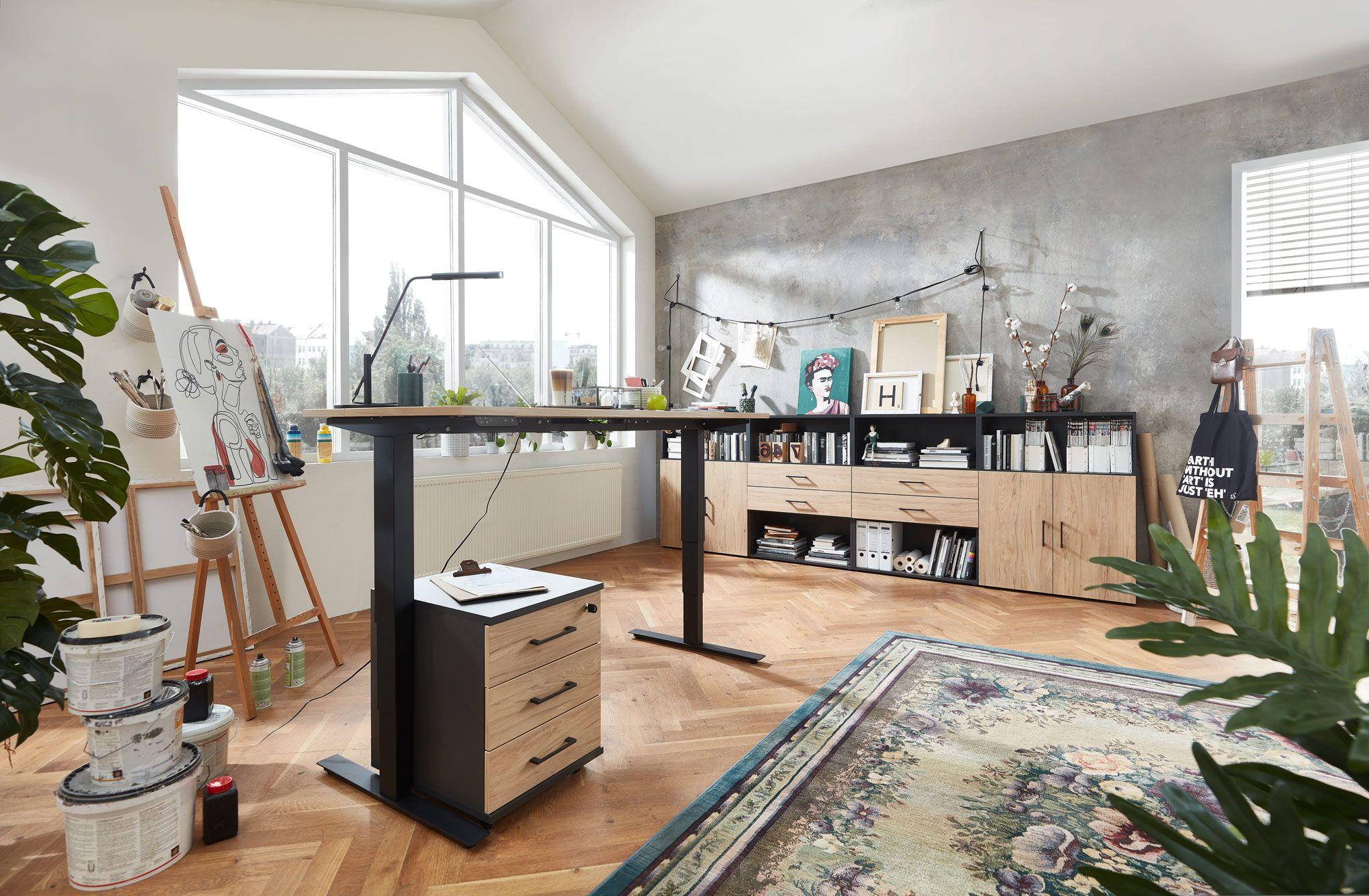Kreatives Home-Office mit höhenverstellbarem Schreibtisch, Künstlerbedarf und Stauraummöbeln in Holzoptik.