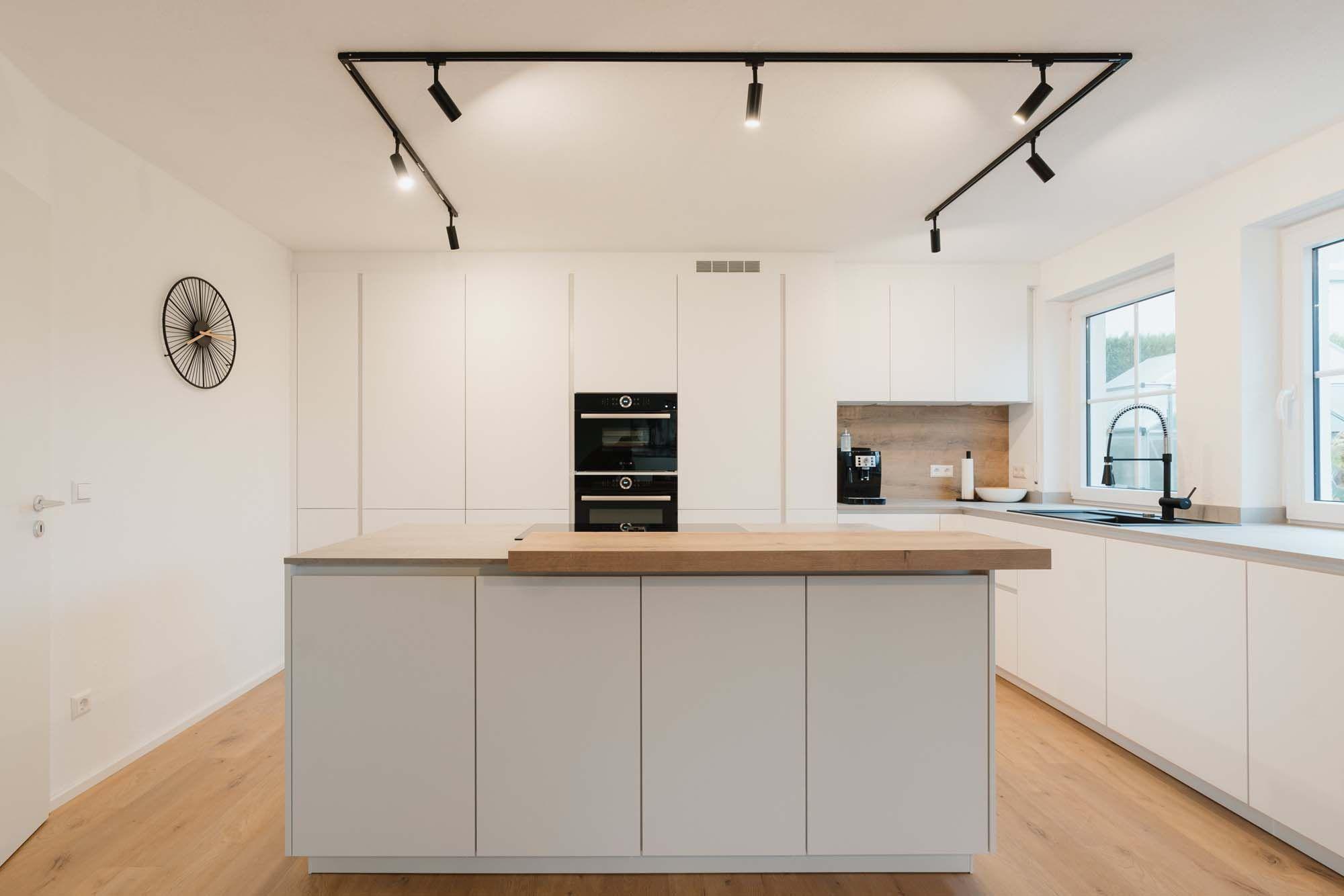 Zeitlose Küche in weißer Eleganz mit Holzdetail