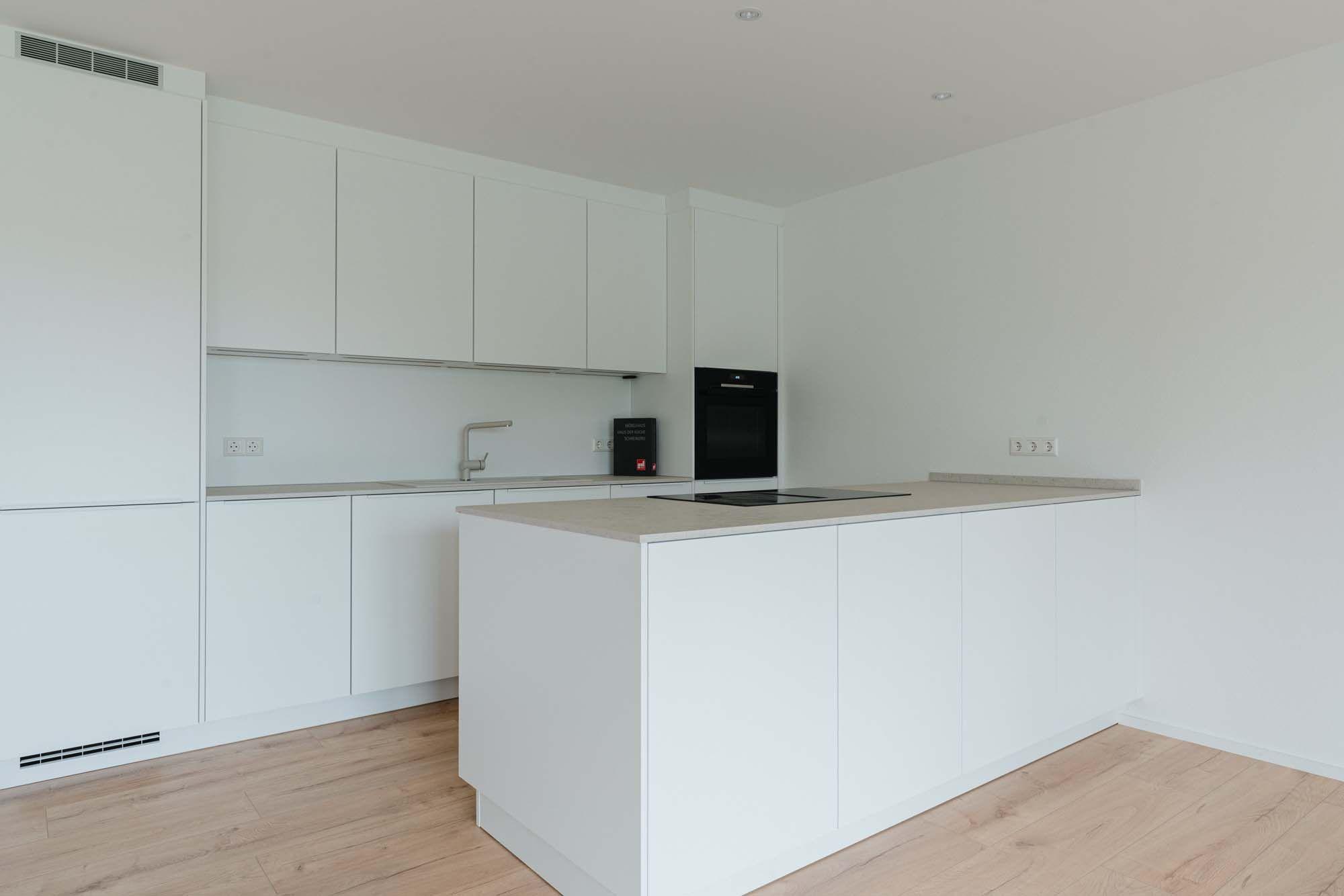 Helle Küche mit passender Garderobe in modernem Weiß