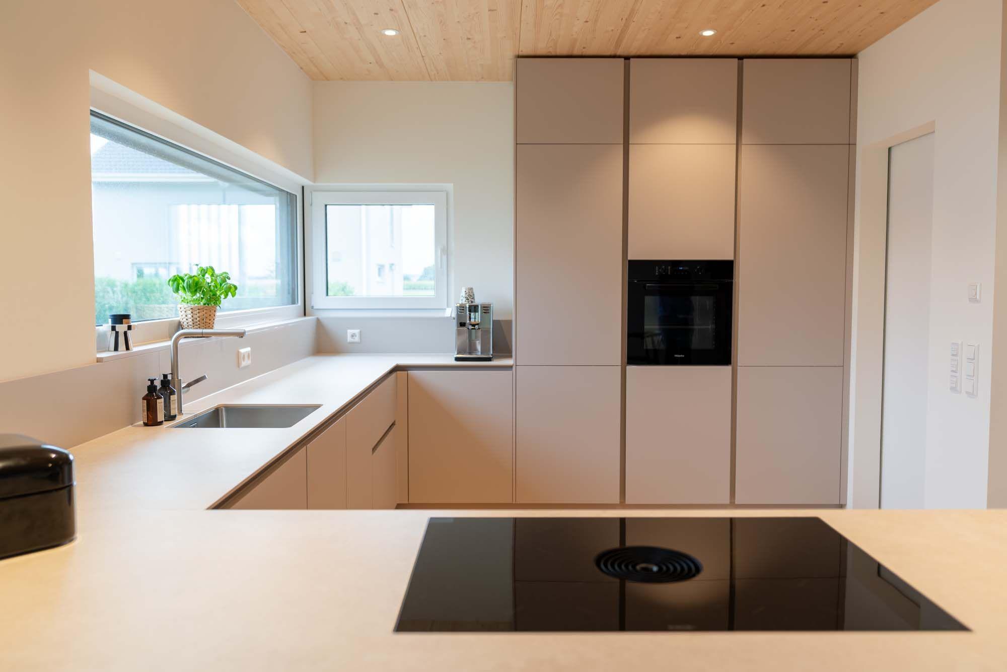 Moderne Küche in warmen Sandtönen mit Kochinsel