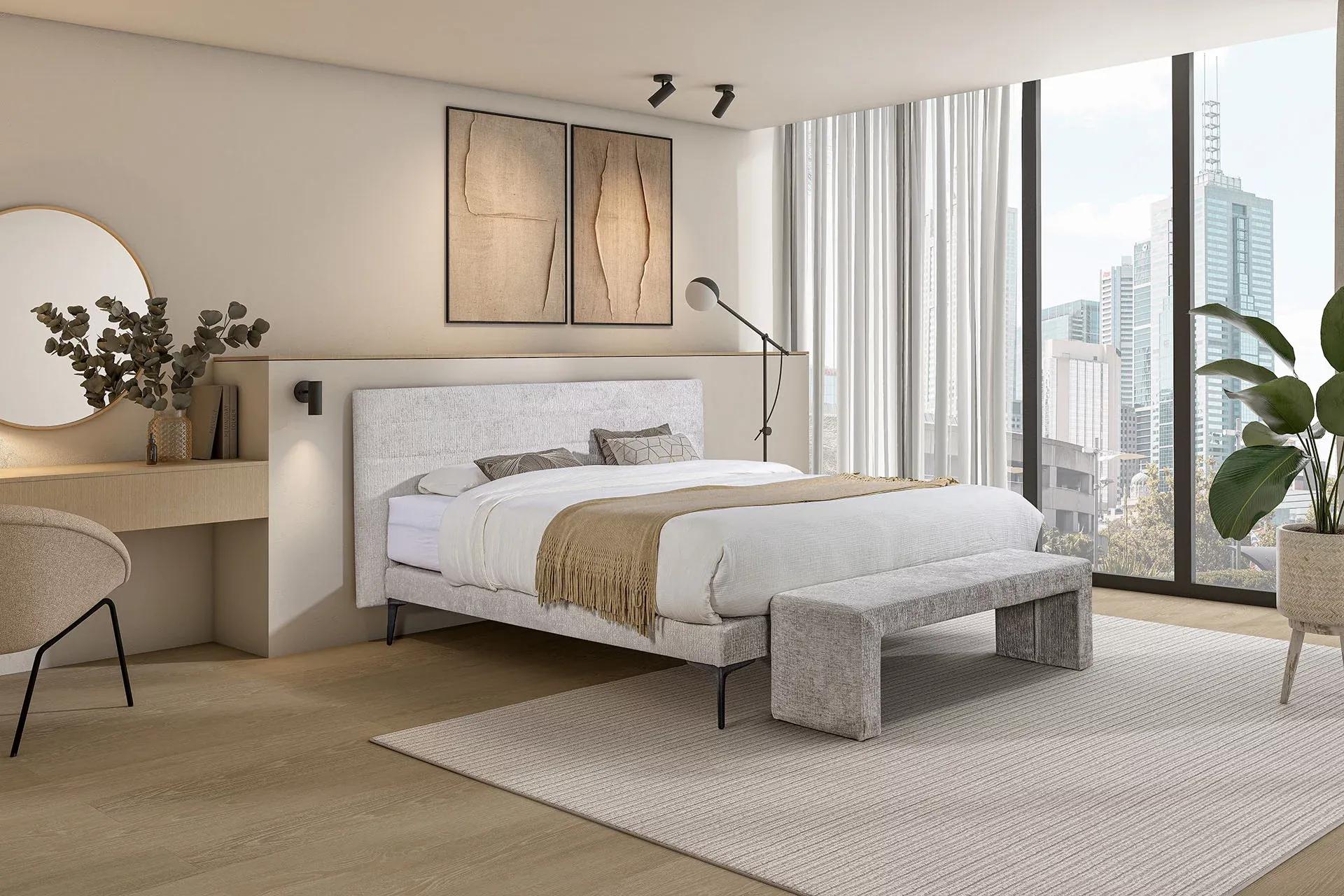 Modern eingerichtetes Schlafzimmer mit Polsterbett, weicher Tagesdecke, Sitzbank und Schminktisch – lichtdurchflutet mit Blick auf die Skyline.