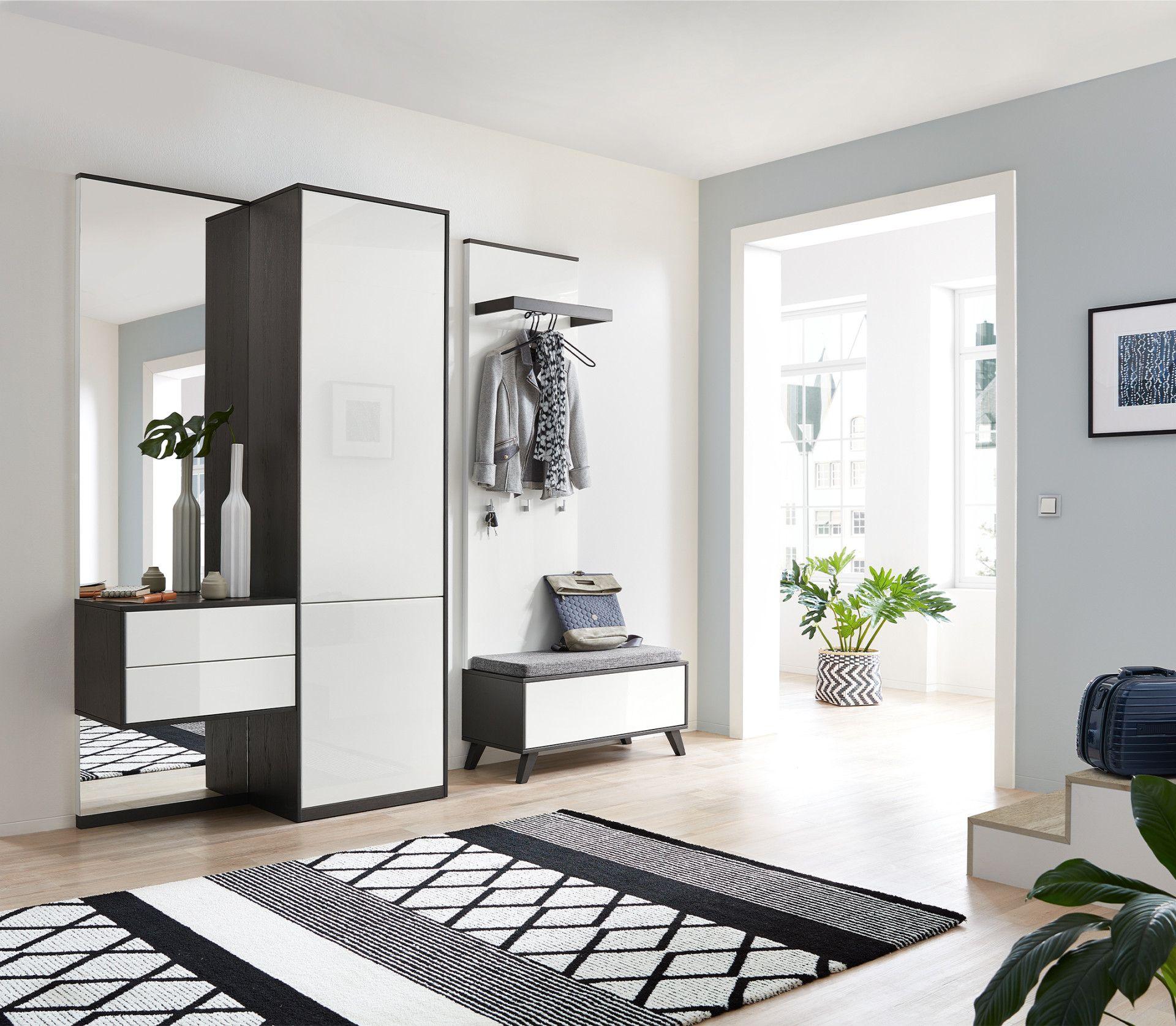 Moderne Dielenmöbel in Weiß und Graphit mit Spiegel, Garderobenpaneel, Sitzbank und offener Wohnraumgestaltung.