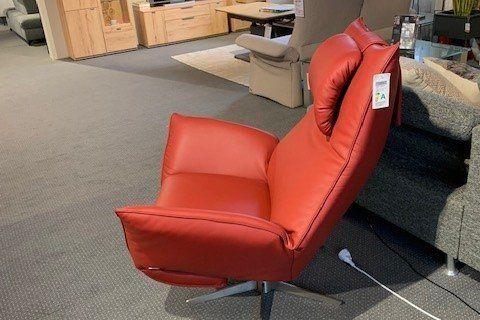Roter Leder-Relaxsessel mit hoher Rückenlehne auf Drehgestell in Möbelhaus-Ausstellung.
